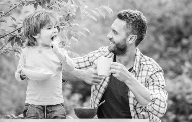 Sağlıklı yemek ve diyet. Süt ürünleri. Babalar günün kutlu olsun. Babasıyla küçük çocuk mısır gevreği yiyor. Baba ve oğul dışarıda yemek yiyorlar. Aile bağları. Birlikte eğleniyoruz. Yeni günün tadını çıkarıyorum. Günaydın.