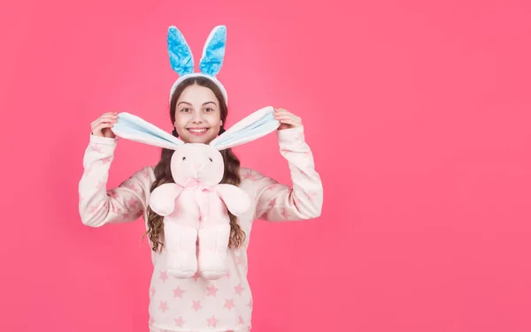 Happy easter teen girl in bunny rabbit ears and pajamas play with toy, copy space, easter — Stock Photo, Image