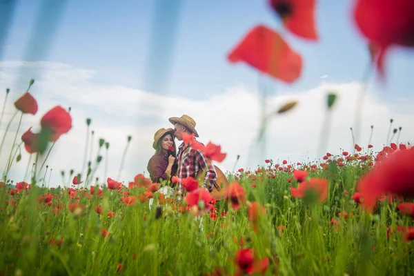 couple in love of man and woman in summer poppy flower field, love