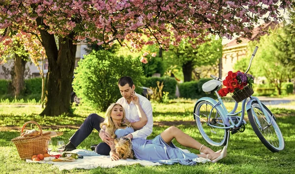 Forever love. celebrating anniversary. happy family in summer park. food and drink. man and woman. romantic couple on picnic. love date in spring. relax under blooming sakura. couple in love