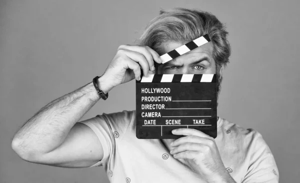 Cinema production. Creative producer. Bearded man hold movie clapper. Film maker. Clapperboard copy space. Comedy or drama. Watch movie. Film director. Actor casting. Shooting scene. Favorite series