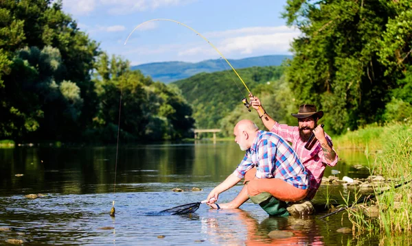 Fishing activity concept. retired dad and mature bearded son. big game fishing. happy fishermen friendship. Two male friends fishing together. fly fish hobby of men. retirement fishery