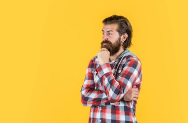 Bir düşüneyim. İyi bakımlı bir saç stili. Erkek güzellik ve moda. Sakallı adam için hippi damalı gömlek. Sakallı, traşsız, vahşi bir adam. Kuaför konsepti. Olgun ve kendinden emin