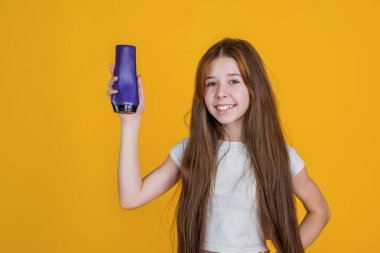 Çocuk duş jeli sunuyor. Vücut bakımı kozmetik banyo. Deri losyonu. Güçlü ve dirençli. Neşeli kız saçını düzleştirmeye hazır. Gençler saçlarını şampuanla temizliyor.
