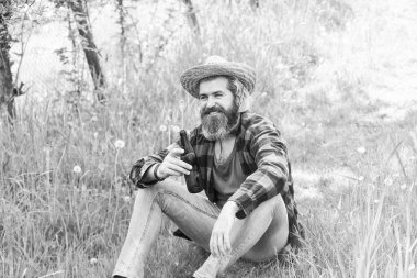 Hasır şapkalı çiftçi bira içer. Yetişkin bahçıvan yeşil çimlerde rahatlar. Bahar doğasının tadını çıkar. Su yazın susuzluğu giderir. Vahşi çiftlik hippileri kareli gömlek giyer. Çiftçilik ve tarım