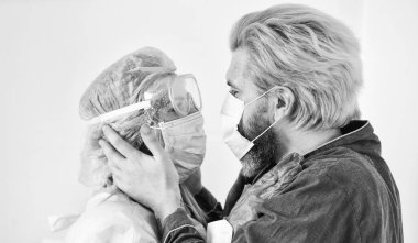 Kişisel temastan kaçının. Koronavirüs salgını önleme. Evde kal. Solunum maskeli adam ve doktor. Birbirine aşık bir çift. Aileni koru. Karantinaya alındı. Hemşire kadın hastaya sarıldı