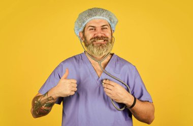 Tıbbi kontrol. Tıbbi yardım. Belirtileri izle. Bedava ilaçlar. Kalp krizini önle. Kalp atışlarını dinliyorum. Sağlık sigortası. Virüs konsepti. Adam hastanede çalışıyor. Sakallı doktor üniformalı steteskop.