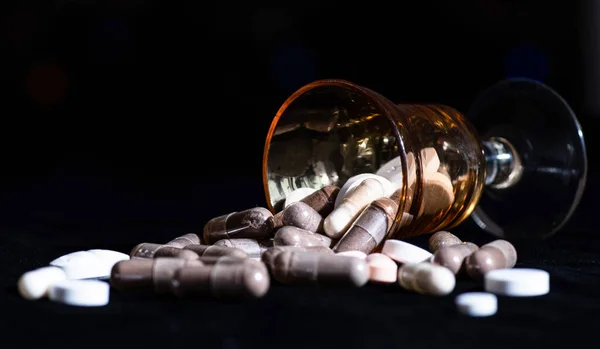 Гелатинова капсула та таблетки фармацевтичні препарати з темного фону впалого скла, таблетки — стокове фото