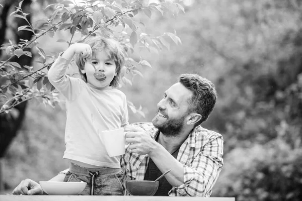 Aile ev yapımı yemeğin tadını çıkarır. Baba oğul yemek yer ve eğlenir. Yemek alışkanlıkları. Babası yemek yiyen küçük bir çocuk. Yaz kahvaltısı. Sağlıklı gıda konsepti. Bebeği besliyorum. Çocuklar için menü — Stok fotoğraf