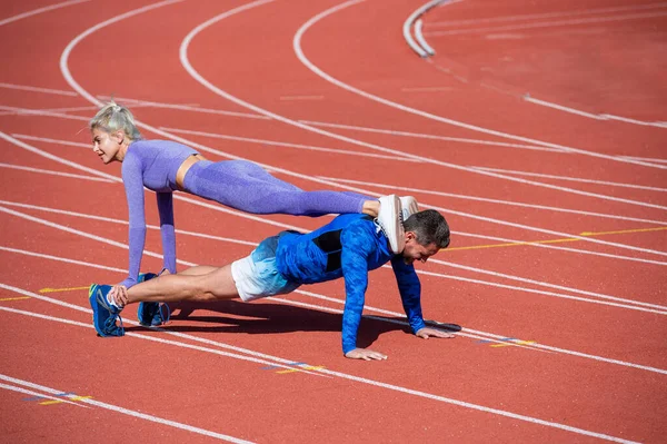Izomerősítés. Atlétikai férfi és nő álló deszkán. férfi és női edző — Stock Fotó