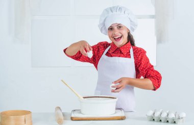 Lezzetin tadına bak. Mutfak ve mutfak. Aşçı şapkalı ve önlüklü çocuk. Mutfakta fırıncı pişirme.