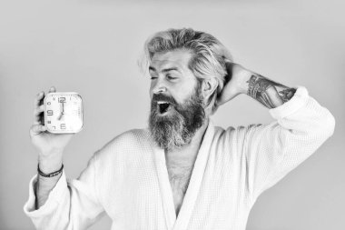 Mutlu adam yatak odasında çalar saatle uyandırılıyor. Olgun Adam Saati Kapatıyor. Olgun bir adam çalar saati kapatır. Yatak odasında dijital çalar saat var. Kalkma vakti. Değişen zaman dilimleri sağlığı etkiler