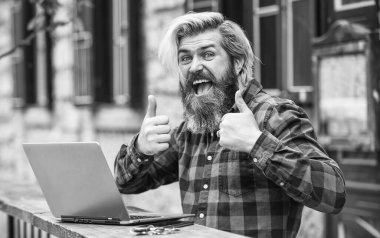 Başparmağını kaldır. Bilgisayarda çalışan olgun bir öğrenci. Pazartesi günü siber alışverişe git. Kafede dizüstü bilgisayarlı mutlu sakallı bir adam. Online uzak eğitim. hipster çalışmak için ilham kaynağı oldu. çevik iş