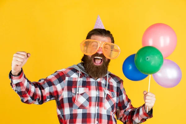 Cheia de felicidade. macho elegante se divertindo no aniversário. Homem barbudo celebra as férias. Aniversário. surpresa para ele. gerente de evento com presente. maduro cara no xadrez camisa com festa balões — Fotografia de Stock