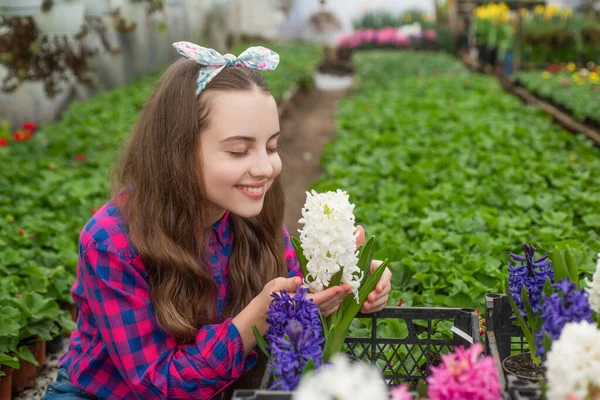 Glad tonåring flicka florist vård kruka växter i växthus, trädgårdsodling — Stockfoto