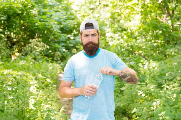 Homme barbu mature avec barbe en vêtements d'été bouteille d'eau libre dans la forêt, après la formation — Photo