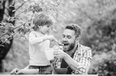 Çocuklar için menü. Aile ev yapımı yemeğin tadını çıkarır. Yemek alışkanlıkları. Babası yemek yiyen küçük bir çocuk. Yaz kahvaltısı. Sağlıklı gıda konsepti. Baba oğul yemek yer ve eğlenir. Bebeği besliyor.