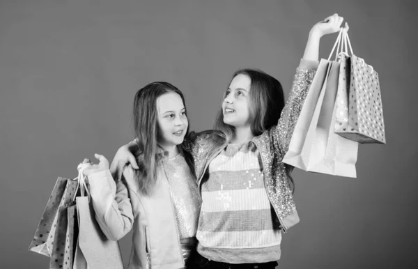 Παιδική μόδα. βοηθός καταστήματος με πακέτο. Πωλήσεις και εκπτώσεις. Αδελφότητα και οικογένεια. εξοικονομήσεις σε αγορές. Μικρά κορίτσια με τσάντες για ψώνια. Ευτυχισμένα παιδιά. Μικρές αδελφές κορίτσι online ψώνια — Φωτογραφία Αρχείου