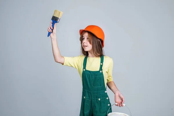 Ha bisogno di una piccola pausa. pittore sull'uso di strumenti di lavoro. ragazza in casco gioca costruttore. costruzione e ristrutturazione. costruzione di bambini. ingegnere adolescente è lavoratore edile. giornata internazionale dei lavoratori — Foto Stock