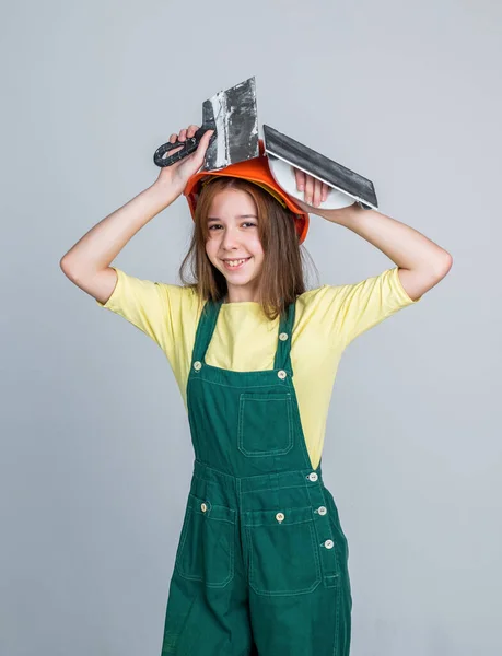 陽気なティーン女の子です制服とヘルメットへら,左官 — ストック写真