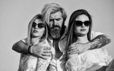 Yaz tatili. İlişkiler dostluk romantizmi. Üçlü konsept. İkisine de aşığım. Çatıdaki partiden arkadaşlar. Havalı hipster ve kadın beyaz elbiseler. Kadınlar ve erkek arkadaşlar sarılıyor. Aile