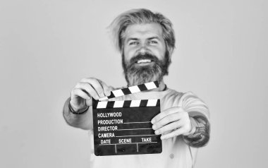 Film izle. Film yönetmeni. Oyuncu kadrosu. Çekim sahnesi. Favori dizisi. Sinema yapımı. Yaratıcı yapımcı. Sakallı adam film alkışlayıcısı tutuyor. Film yapımcısı. Alkış tahtası kopyalama alanı. Komedi ya da dram