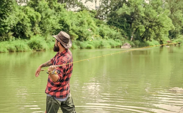 Storie di pesci qui. hobby e attività sportive. pothunter. pescatore barbuto in acqua. weekend estivo. Pesca d'altura. uomo maturo pesca a mosca. uomo cattura il pesce. pescatore con canna da pesca — Foto Stock