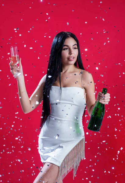 Szexi nő iszik pezsgő üveg alatt esik konfetti, évforduló — Stock Fotó