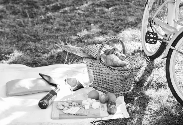 Cesta de picnic con comida en manta. primavera comiendo al aire libre. Día de la familia. todas las mercancías para el picnic. cita de amor. bicicleta de época sobre hierba verde. comida verde del parque de verano. teniendo un sabroso almuerzo. hora de cenar — Foto de Stock