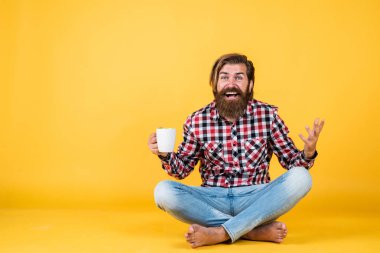 Bu hoşuma gitti. Sana da günaydın. Enerjik, sıcak bir içecek. İlham için biraz kahveye ihtiyacım var. Güne mükemmel bir başlangıç. Şaşırmış sakallı adam sabah kahvesini içiyor. Adam fincandan sıcak çay içiyor.