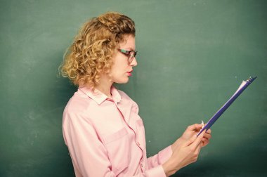 Öğretmen ödevlerini kontrol ediyor. Akıllı kadın tablet belgeleri tutuyor. Kişisel profilini oku. Başvuranlar için tahmini kompozisyon. Okul projesi. Edebiyat öğretmeni kompozisyon okudu. Etkileyici özgeçmişi oku