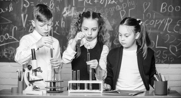 A diákok kémiát tanulnak az iskolában. A gyerekek szeretik a kémiai kísérleteket. A vegyi anyag feloldódik egy másikban. A felfedezés olyan izgalmas. Vegyi reakció akkor lép fel, amikor az anyag új anyagokká változik — Stock Fotó