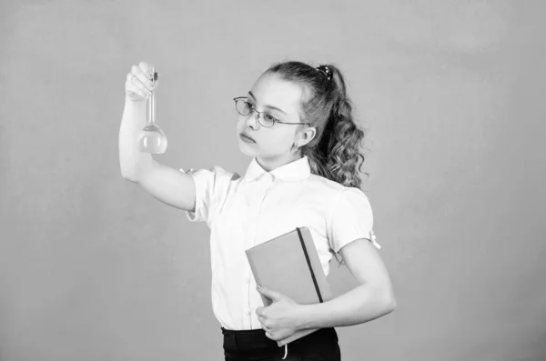 De vuelta a la escuela. pequeña chica inteligente con frasco de prueba. educación y conocimiento. lección de bilogía de estudio infantil con nota. investigación científica en laboratorio. Pequeña colegiala. Farmacéutico seguro — Foto de Stock