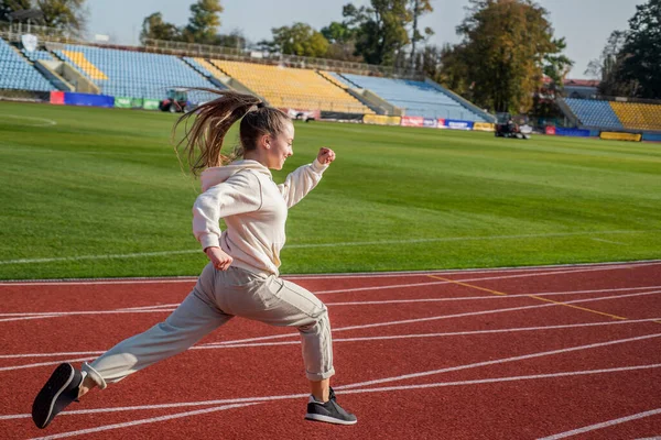 La regola nella corsa è solo correre. Ragazza energica correre sulla pista di corsa. Scuola di sport — Foto Stock