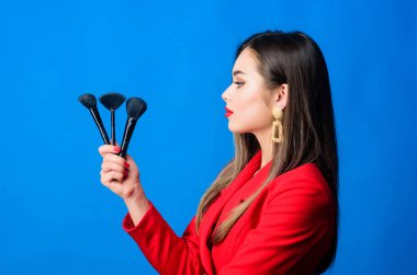 Makyöz konsepti. İyi görünüyorsun ve kendine güveniyorsun. Profesyonel makyaj malzemeleri dükkanı. Makyaj kursları. Güzel bayan, kırmızı dudaklar yap. Makyaj fırçası kullanan çekici bir kadın. Mükemmel ten rengi