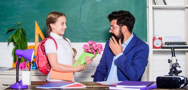 Zurück zur Schule. Glücklicher Lehrertag. kleines Schulmädchen mit Blumenstrauß. Blumengeschenk für den besten Lehrer. Wissenstag ist der 1. September. Lehrertag. Tochter und Vater mit Blumen — Stockfoto