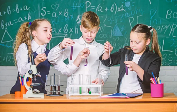化学顕微鏡。小さな子供たちは学校の研究室で化学を学ぶ。顕微鏡で生物学の実験をしています。研究室の小さな子供たち。ラボの顕微鏡。近代医学の向上 — ストック写真