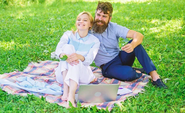 Семья наслаждается отдыхом на природе. Пара бородатых мужчин и блондинка расслабляют природу, сидя на зеленом травяном лугу. Концепция расслабления и вдохновения. Пара с ноутбуком расслабиться природной среды — стоковое фото