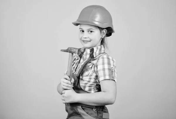 Niña pequeña reparación con martillo en el taller. Herramientas para mejorar. Reparar. Desarrollo del cuidado infantil. Profesión futura. Arquitecto ingeniero constructor. Trabajadora de niños con gorra dura. trabajo en taller de reparación — Foto de Stock