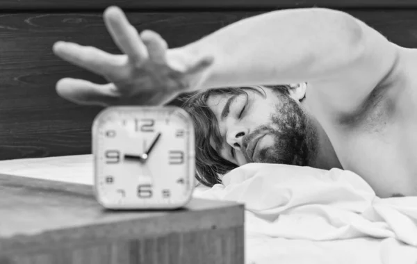 Um jovem acordando na cama e estendendo os braços. Homem estendido na cama. Acorde de manhã homens. — Fotografia de Stock