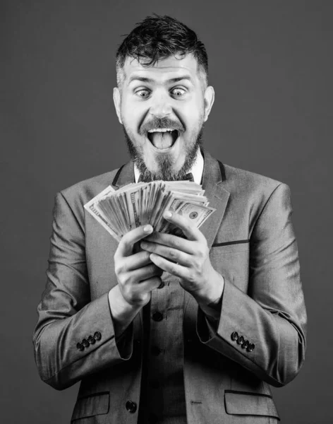 Won a cash prize. Bearded man holding cash money. Making money with his own business. Business startup loan. Rich businessman with us dollars banknotes. Currency broker with bundle of money