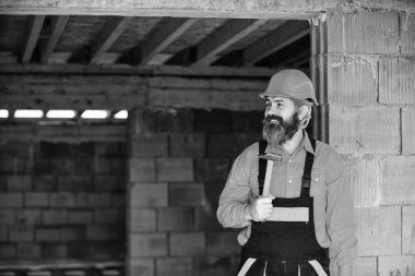Yapı ve inşaat. Yetenekli mimar tamir ve onarım. Mühendis. Olgun sakallı adam çekiç kullanır. Bitmemiş bir binada inşaatçı. Kasklı profesyonel bir tamirci.