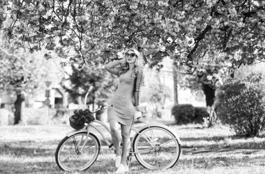 Atletik kadın retro bisiklet sürüyor. Dinlen ve seyahat et. Bisikletle seyahat et. Hafta sonu konsepti. Bahar tatili. Bisiklete binmek. Kız ve sakura çiçeği. Bisiklet Turları. Bahçeye bir gezi. Kiraz ağacı çiçek açıyor.