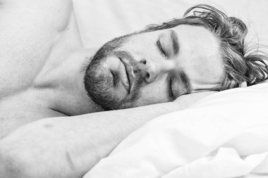 Her gece yeteri kadar ve tutarlı bir uyku çek. Ne kadar uykuya ihtiyacın var? Sakallı adam yastıkta dinleniyor. Uzman tavsiyeleri daha iyi uyumak için. Yakışıklı adam yatakta uzanıyordu.