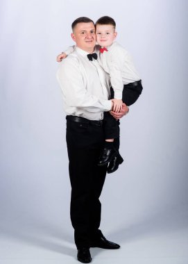 Baba ve oğul takım elbise içinde. Küçük çocuk ve baba beyefendi. Aile günü. Erkek modası. Ebeveynlik. Babalar günü. Babası olan bir çocuk. İş toplantısı. Smokin tarzı. Düğün partisi. Tasarım ekibi. Sarıl