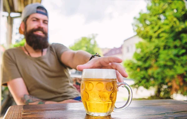 Élvezem az alkoholmentes sört. Szakállas férfi szeszes italt szed a bárban. Hipster ül az alkoholos italokkal a kocsmában. Társadalmi alkoholista, nem alkoholista. — Stock Fotó