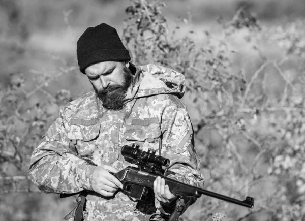 Man hunter with rifle gun. Boot camp. Bearded man hunter. Army forces. Camouflage. Military uniform fashion. Hunting skills and weapon equipment. How turn hunting into hobby. Cowboy with gun