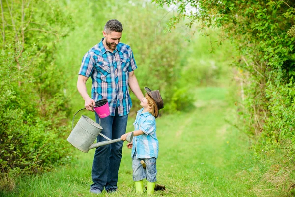 happy earth day. Family tree nursering. Eco farm. small boy child help father in farming. use watering can and pot. Garden equipment. father and son in cowboy hat on ranch. Tender moment