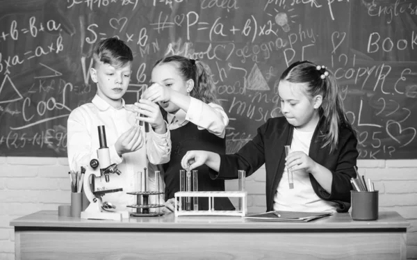 Boy and girls enjoy chemical experiment. Organic chemistry is study of compounds containing carbon. Fascinating chemistry. Basic chemical reactions. Group school pupils study chemistry in school