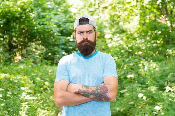 Volwassen man met baard en snor in zomershirt en pet in bos, levensstijl — Stockfoto